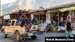 Taliban soldiers fighters ride through town in a pickup truck in Panjshir in December 2021.