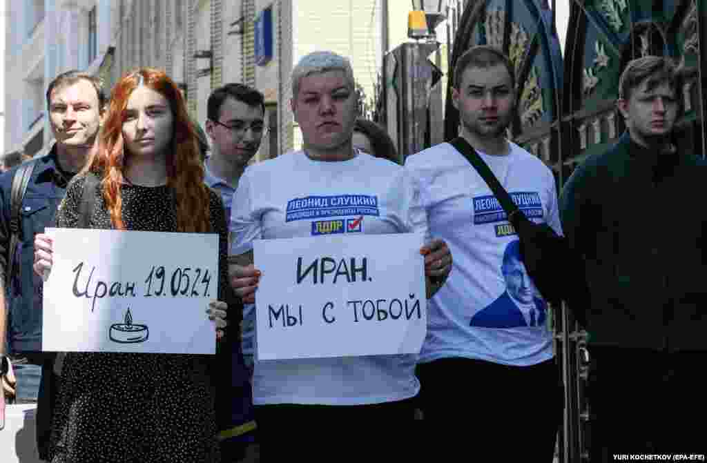 Москвадагы элчиликтин жанында &ldquo;Иран - 19.05.2024&rdquo;&nbsp; жана &ldquo;Иран, биз сени мененбиз&rdquo; деп жазылган плакаттарды кармап тургандар.&nbsp;