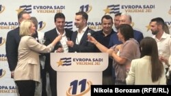Водачът на листата Милойко Спаич (в средата) празнува победата на формацията, която е създадена преди по-малко от година