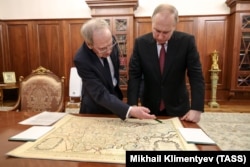 Rusiye Federatsiyasınıñ prezidenti Vladimir Putin ve Rusiye Federatsiyasınıñ Anayasa mahkemesiniñ reisi Valeriy Zorkin (sağdan solğa) Frenkistan qıralı XIV Lüdovikniñ zamanında yapılğanı iddia etilgen haritanı baqalar. Moskva, 2023 senesi mayısnıñ 23-ü