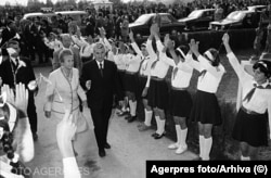 Vizita lui Nicolae si Elena Ceausescu in judetul Olt (1979). Pionierii erau scoși pe stradă pentru a îi întâmpina pe cei doi dictatori și a le aduce omagii. Copiii din clasele II-VIII purtau uniforme de pionier: cămasă albă, cravată roșie, fustă/pantaloni bleumarin, șosete albe.