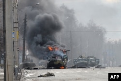 Харьковдогу салгылашуудан кийин орусиялык БТР аскердин сөөгүнүн жанында күйүп жатат, 27-февраль, 2022-жыл.