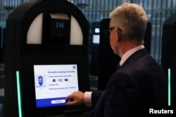 Un bărbat operează un chioșc automatizat EES în timpul unei demonstrații a Sistemului de intrare/ieșire al Uniunii Europene (EES) la terminalul Eurotunnel din Folkestone, Marea Britanie, 23 septembrie 2025.