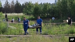 Anchetatorii cară trupul neînsuflețit al lui Starovoit, la Odințovo, lângă Moscova, luni, 7 iulie.