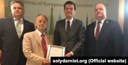 Mustafa Cemilev ABD devlet kâtibiniñ yardımcısı Mayk Pompeodan ABD-niñ Qırım siyasetine dair Beyannamesiniñ metnini aldı. Kıyiv, 2018 senesi ikl yaz ayınıñ 26-sı
