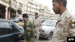 Disarmed members of an awakening council man a checkpoint in Baghdad's Fadel district on April 2.