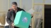 Сайлау комитеті мүшесі бюллетень салынған урнаны көтеріп келеді. Бұхара, 27 желтоқсан 2009 жыл. (Көрнекі сурет)