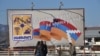 Nagorno Karabakh --Pedestrians walk past a poster bearing a flag of Nagorno-Karabakh in Stepanakert, November 24, 2020