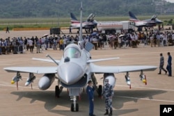 Китайские военнослужащие стоят возле истребителя J-10C во время 13-й Китайской международной авиационной и аэрокосмической выставки, также известной как Airshow China, в сентябре 2021 года