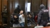 Част от 19-имата подсъдими за терористичната атака в "Крокус Сити Хол", изолирани в съдебната зала на Втори западен окръжен военен съд в Москва, 4 август 2025 г.