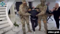Екранна снимка от видеоклип, публикуван в канала на СБУ в Ютюб, на който се вижда задържането на мъж, заподозрян в шпионаж.
