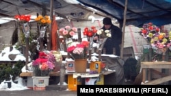 Вокруг строительного забора под открытым небом вот уже четыре года ютятся продавцы цветов. Им обещают, что в этом строящемся павильоне им выделят площади для небольших магазинчиков