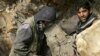 Afghan miners drill into rock in a makeshift emerald mine in the Panjshir Valley (file photo)