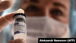 RUSSIA -- A medical worker holds a vial with Russia's Sputnik V vaccine against the coronavirus at a vaccination point at the GUM department store in Moscow, January 18, 2021.
