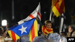 Каталониялык бала "Estelada" (Күнкорсуз Каталониянын туусун) туусун желбиретип турат. Барселона, 27-сентябрь 2015.