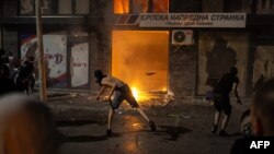 Протестиращи хвърлят предмети по централата на управляващата Сръбска прогресивна партия във Валево по време на антиправителствени протести на 16 август 2025 г.