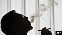 China's Hon Lik, inventor of the e-cigarette, tests his invention in Beijing.