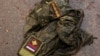Российская военная форма на дороге в селе Дмитровка Киевской области, которое было освобождено ВСУ после уничтожения в этом селе колонны российских бронированных машин, 1 апреля 2022 года