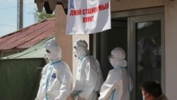 Специалисты в защитной одежде у дневного стационара в Бишкеке для зараженных коронавирусной инфекцией.