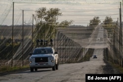 Un vehicul echipat cu dispozitive de bruiaj electronic circulă pe un drum acoperit cu plase anti-drone, 2 octombrie 2025.