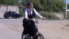 Велосипед теуіп келе жатқан оқушы қыз.