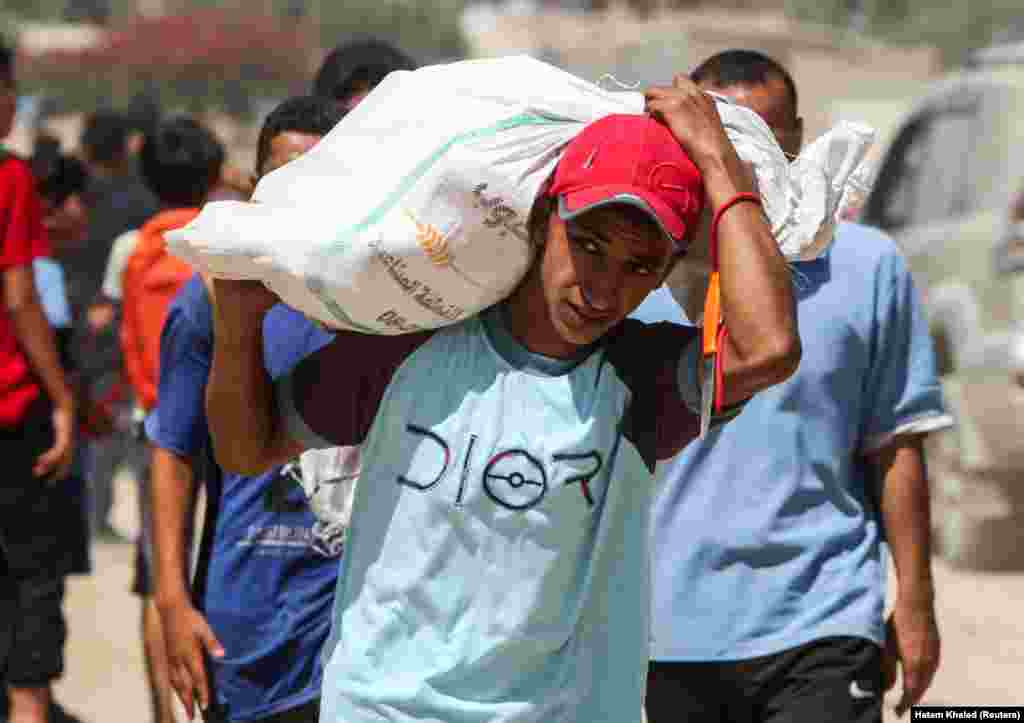 Një palestinez duke bartur një thes me ndihma që erdhi me parashut, më 31 korrik.