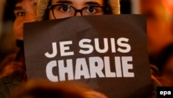 «Je Suis Charlie» ("Мен Чарлимін") деген жазуы бар плакат ұстап тұрған адам. Ницца, 7 қаңтар 2015 жыл.
