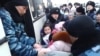 Полиция баспана мәселесіне байланысты наразылық білдірген тұрғындарды балаларымен бірге автобусқа күштеп мінгізіп жатыр. Астана, 6 наурыз 2014 жыл. (Көрнекі сурет)