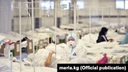 Кыргызстандагы стационарлардын биринен тартылып алынган сүрөт. Медайым бейтапка жардам көрсөтүүдө.