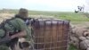 Орыс тілінде сөйлейтін "жиһадшылар" туралы видеодан алынған скриншот. Болжам бойынша, видео Сирияның Кобани қаласы маңында түсірілген. 